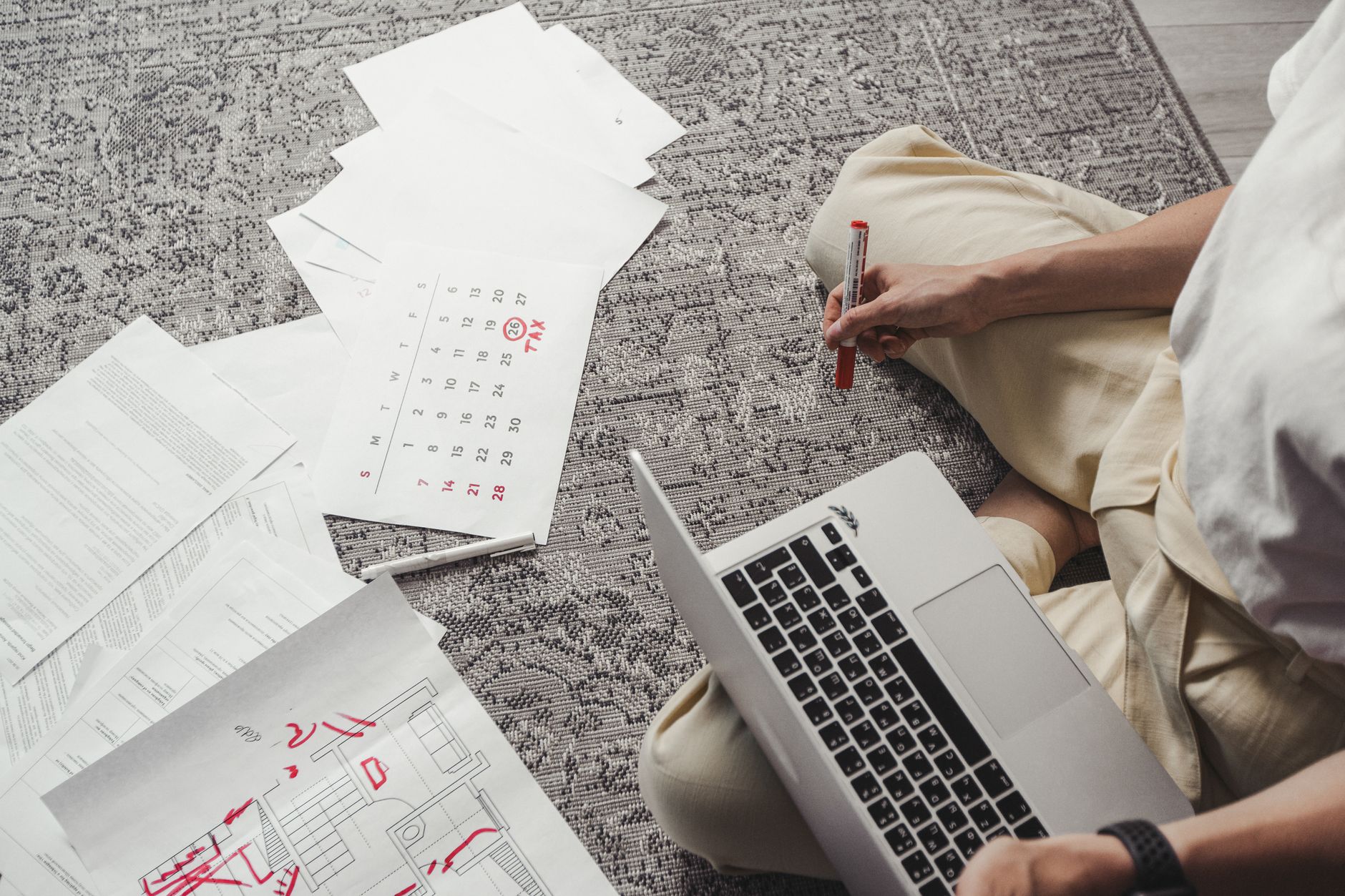 Young man working on plans with laptop and calendar, organizing tasks and schedules.