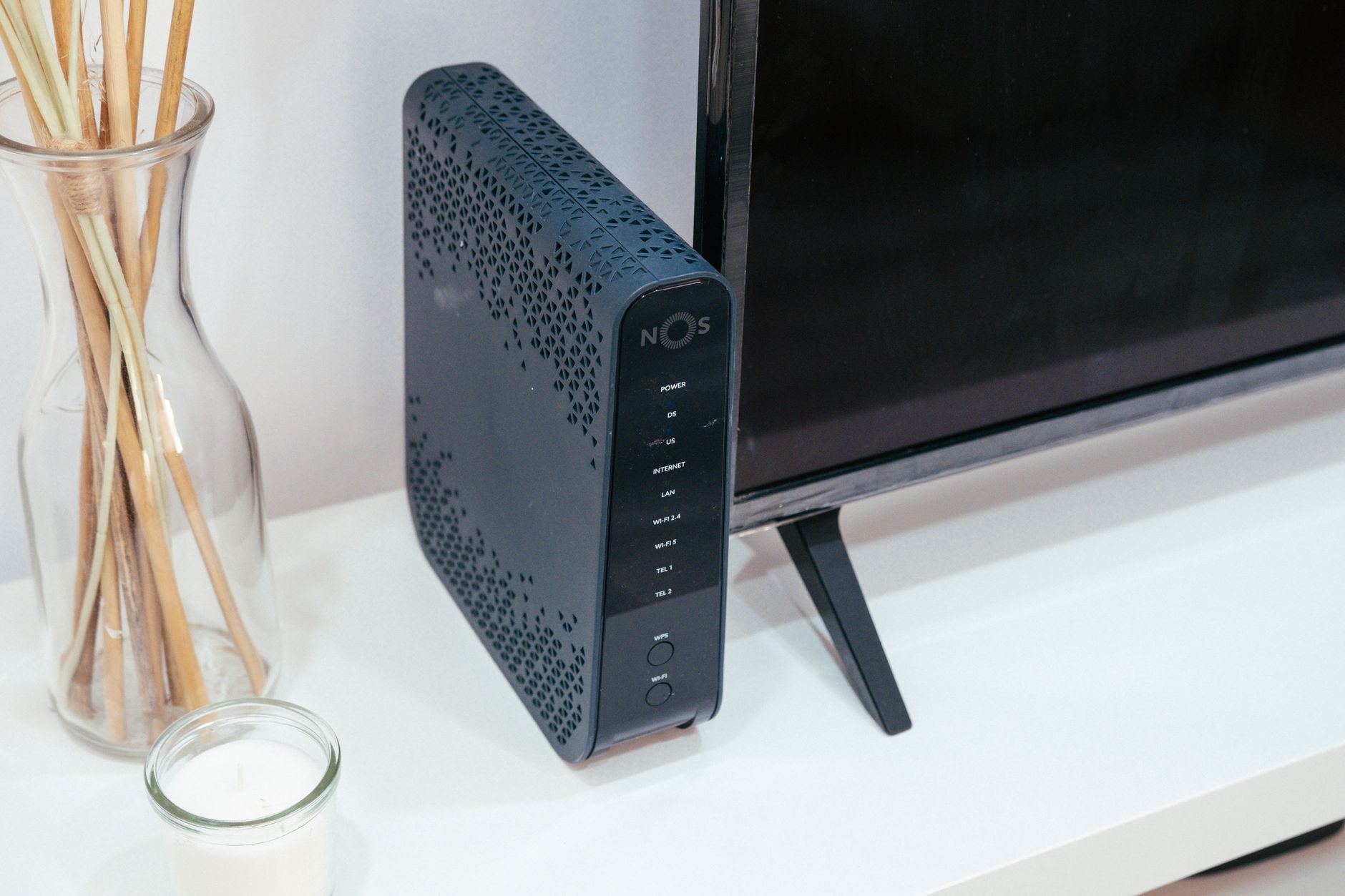 A sleek home technology setup featuring a router, glass decoration, and television.