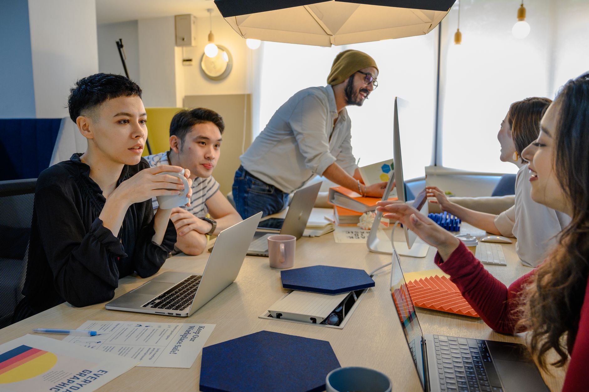 Diverse team collaborating in a modern office environment, engaging in a creative brainstorming session.