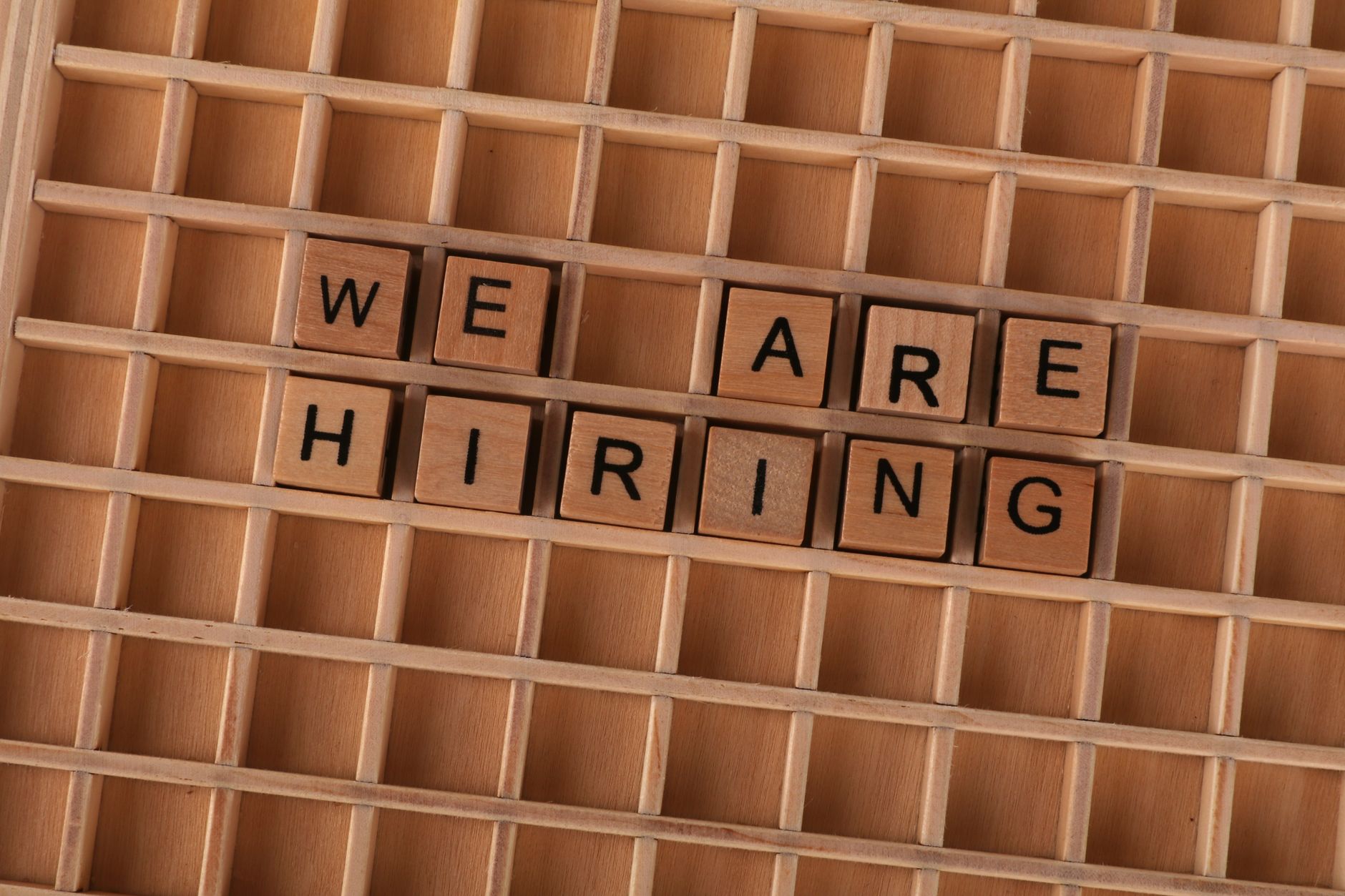 Wooden tiles on a board forming the phrase 'We Are Hiring', ideal for job announcements.