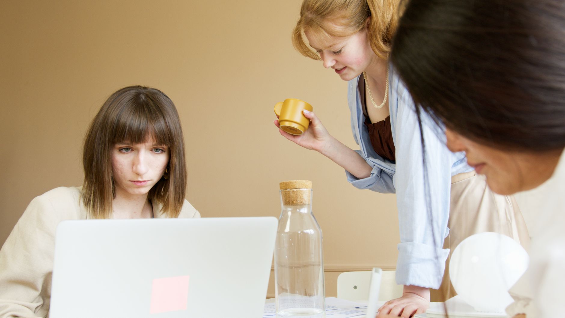 A group of diverse women working together in a modern office environment, fostering creativity and collaboration.