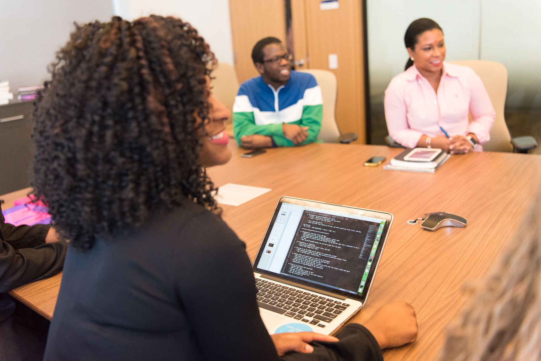 A diverse group of professionals collaborating in a modern office environment with laptops and technology.